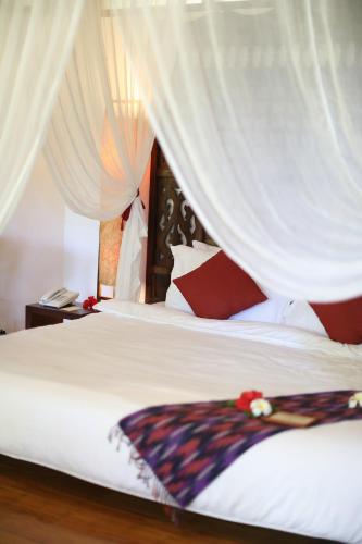 a bedroom with a bed with red and white pillows at Mandala Spa & Resort Villas in Boracay
