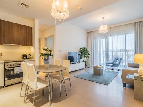a kitchen and living room with a table and chairs at Chic 1BR in Park Heights 2 - Dubai Hills in Dubai