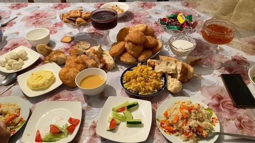 una mesa con muchos platos de comida. en Kausar, en Karabulak
