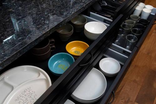 a drawer full of dishes and bowls in a kitchen at The Villa Miyako in Hirara