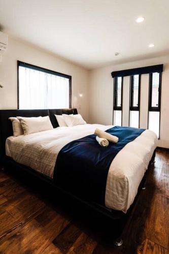 a bedroom with a large bed with a teddy bear on it at The Villa Miyako in Hirara