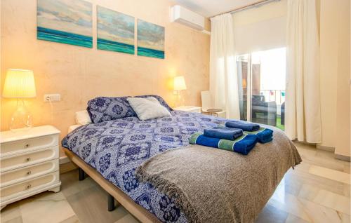 ミハス・コスタにあるAmazing Apartment In Mijas Costa With Swimming Poolのベッドルーム1室(青い掛け布団付きのベッド1台付)