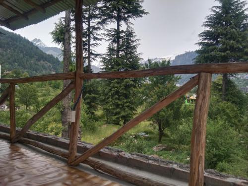 a view from the porch of a house overlooking the mountains at The Doors Inn in Manāli