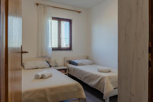 a room with two beds with towels on them at APARTMANI JAMAN in Vrsi