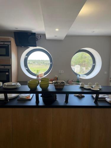 a kitchen with two round windows and a counter with bowls at Château Catherine de Montgolfier B&B et Gites in Narbonne