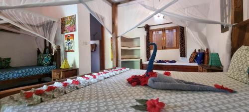 a bedroom with a bed with red flowers on it at Salama & Mbuyuni Bungalows in Matemwe