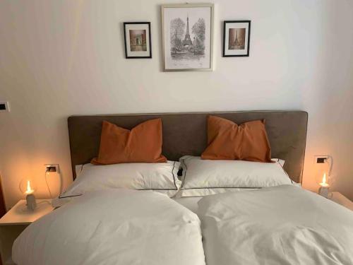 una camera con 2 letti con cuscini arancioni di Darling Home a Merano