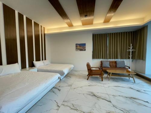 安平的住宿－台南Fun電 親子旅店 ，一间卧室配有两张床、一张桌子和一把椅子