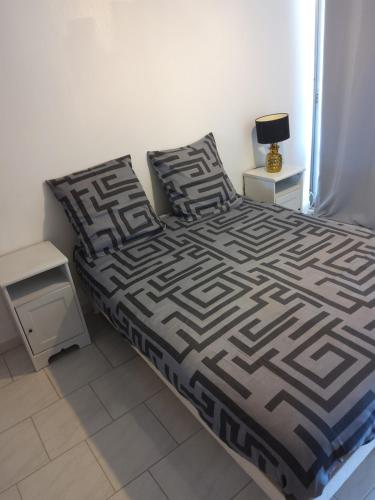 um quarto com uma cama com um edredão preto e branco em Grand t2 vue mer em La Ciotat