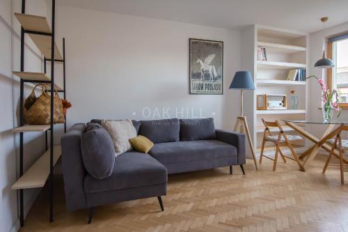 een woonkamer met een blauwe bank en een tafel bij Signe Home in Gdańsk