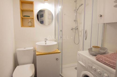 a bathroom with a toilet and a sink and a shower at Signe Home in Gdańsk