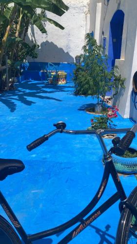 a bike parked in front of a blue floor at Riad mama Aicha in Asilah
