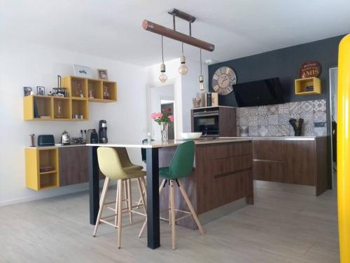 a kitchen with a table and chairs in a kitchen at Maison moderne dans la drome des collines in Bren
