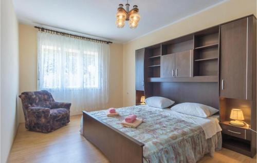 a bedroom with a large bed and a chair at Nice Apartment In Marcana With Wifi in Marčana
