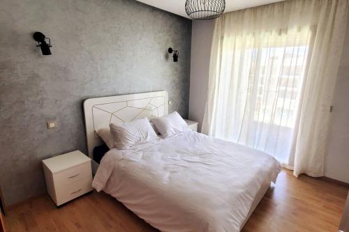 馬拉喀什的住宿－Marrakesh Pearl Gardens Amazing 2 Bedrooms apartment，卧室配有白色的床和窗户。
