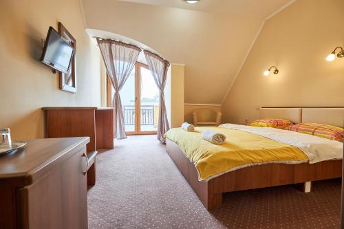 a bedroom with two beds and a desk and a television at Holidays Club Resorts in Hajdúszoboszló