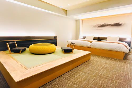 a bedroom with two beds and a large yellow ottoman at Yuzanso in Otsu