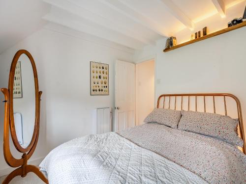 a bedroom with a bed and a mirror at Southview Cottages in Poynings