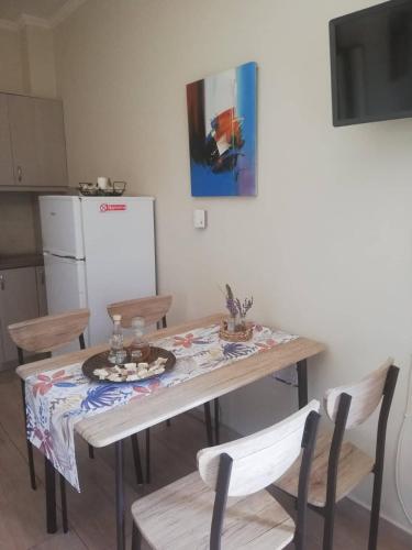 a kitchen with a table with chairs and a refrigerator at Olivia in Chania Town