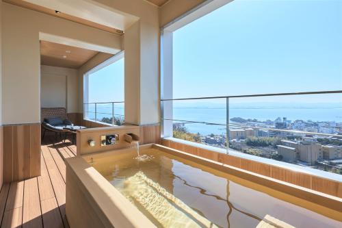 a room with a bath tub with a large window at Yuzanso in Otsu