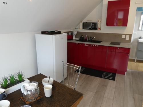 uma cozinha com armários vermelhos e um frigorífico branco em Les Cactus em Bagnères-de-Bigorre