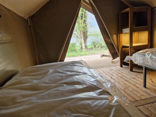 ein Bett in einem Zelt in einem Zimmer in der Unterkunft camping les rives du lac in Bois Morin