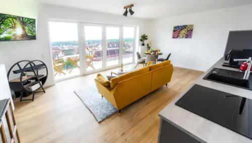 a living room with a yellow couch and a kitchen at Haus Sebald in Sankt Martin