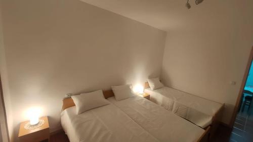 Dormitorio pequeño con 2 camas y 2 luces en Casa da Clarinha, en Castelo de Paiva