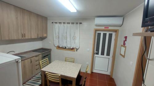 a small kitchen with a table and a table and chairs at Casa da Clarinha in Castelo de Paiva