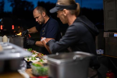 Due uomini stanno preparando il cibo in una cucina di Easy Camping a Spielberg