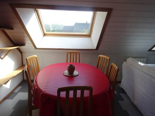 a red table in a room with a window at T3 ecolo en campagne in Le Roc-Saint-André