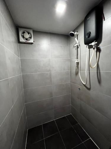 a bathroom with a shower with a phone on the wall at liora Cambodia - Riverside Loft Apartments in Phnom Penh