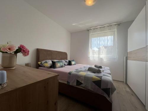 ein Schlafzimmer mit einem Bett und einer Vase mit Blumen in der Unterkunft Apartment in Medulin with Terrace, Air conditioning, Wi-Fi (4634-5) in Medulin