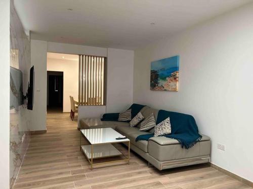 ein Wohnzimmer mit einem Sofa und einem Tisch in der Unterkunft A flat in the heart of bugibba in St Paul's Bay
