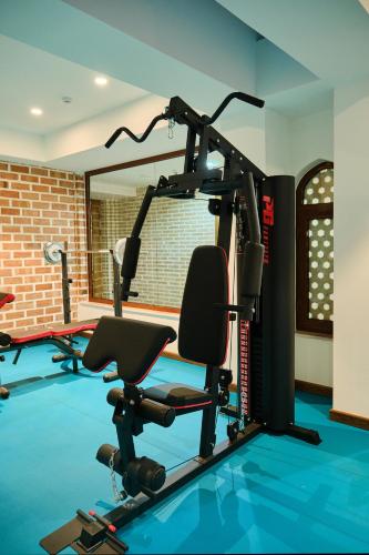 a gym with a treadmill and a chair in a room at Kosh Havuz boutique hotel in Samarkand
