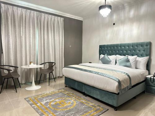 1 dormitorio con 1 cama, mesa y sillas en Sea Shore Hotel Apartment Khorfakkan, en Khor Fakkan