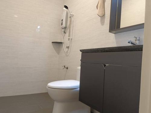 uma casa de banho com um chuveiro, um WC e um lavatório. em Guesthouse 26 Villa/Sejati/Mile7 em Sandakan