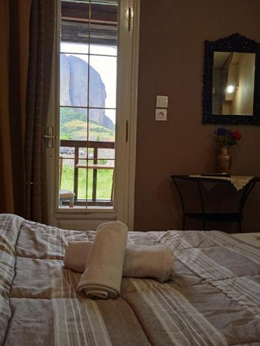 a bed with two towels on it with a window at Kostis Hause in Kastrákion