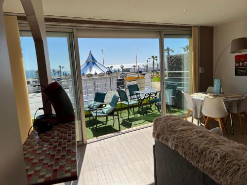 - un salon avec un balcon offrant une vue sur l'océan dans l'établissement Rivage, au Barcarès