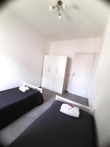a bedroom with two beds and two white cabinets at Dolce casa spiaggia&relax in Lotzorai