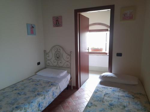a bedroom with two beds and a door with a window at Poggio Desto Bed & Breakfast in Quarrata