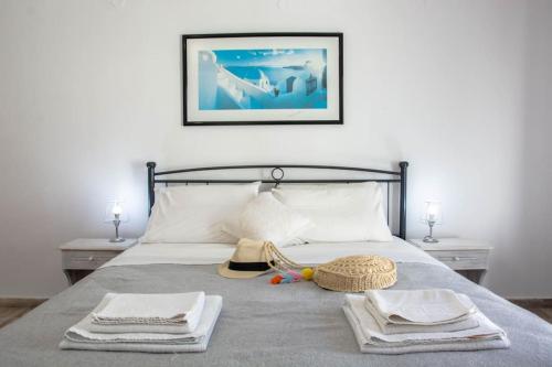 ein Schlafzimmer mit einem Bett mit Handtüchern und einem Hut darauf in der Unterkunft White wave studio 1 , 3min walk from Kamari beach in Kamari