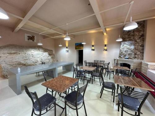 Tafileh-Sila'a Heritage Village في الطفيلة: مطعم بطاولات وكراسي وجدار حجري