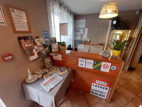 een winkel met een balie en een tafel in een kamer bij Logis Hôtel - Les Pasteliers in Lavaur