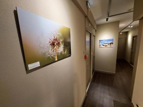 a hallway in an office with paintings on the wall at Logis Hôtel - Les Pasteliers in Lavaur