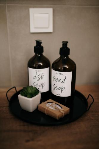 two bottles of hand sanitizer on a plate with a cutting board at VIP apartments Bitola in Bitola
