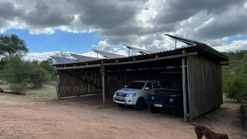 a white truck parked in a building with solar panels at Lengau Lodge in Grietjie Nature Reserve