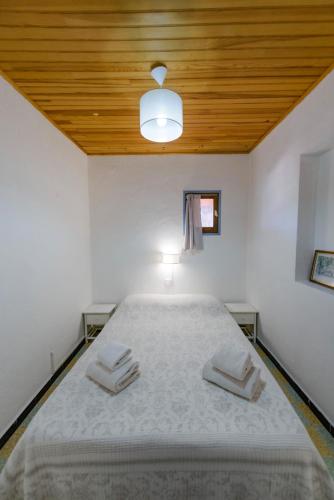 a bedroom with a large bed with a wooden ceiling at Résidence Itylon in Cargèse
