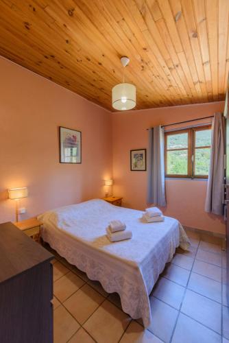a bedroom with a bed with two towels on it at Résidence Itylon in Cargèse