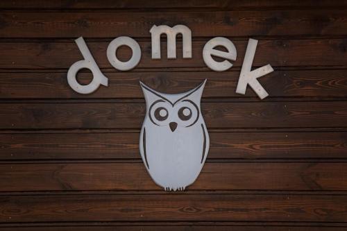 un cartel con un búho en una pared de madera en Domek Sówka na Kociewiu 